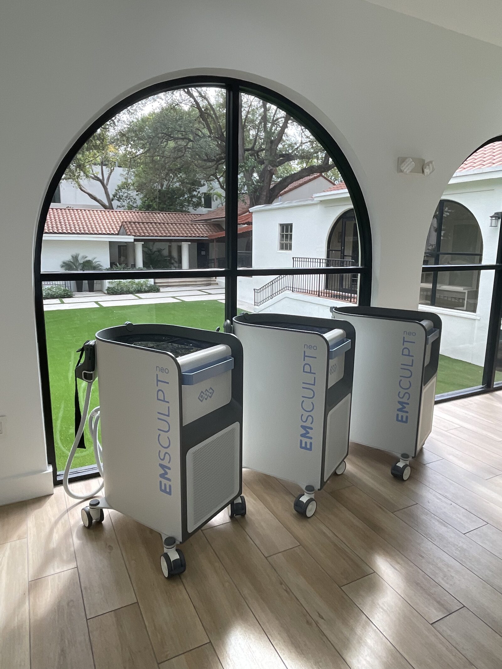 Two clients receiving side-by-side Emsculpt Neo body sculpting treatments at Miami Skin Spa in Brickell, Miami